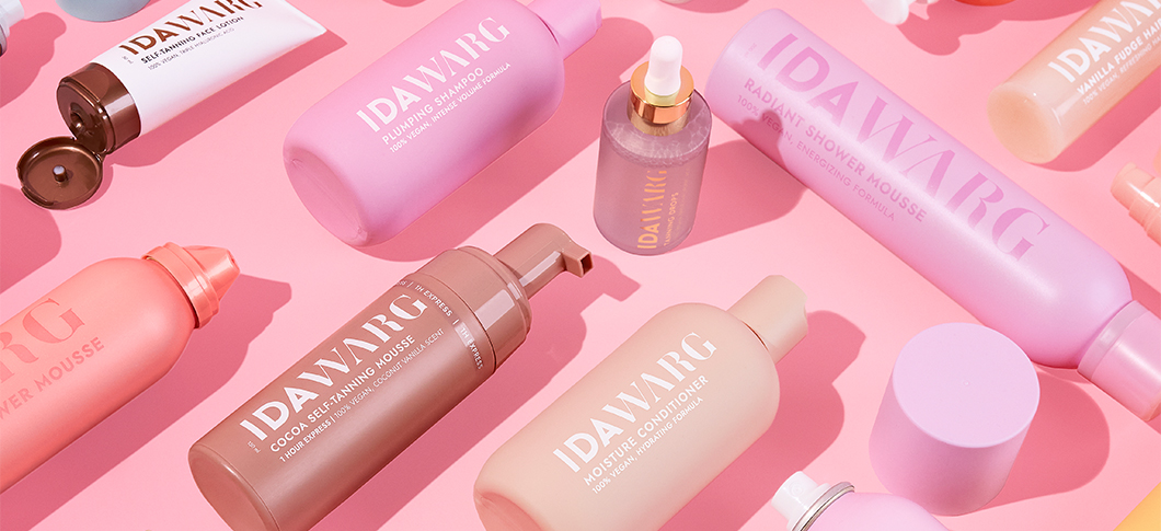 Her ses IDA WARG produkter i forskellige farver arrangeret på en lyserød baggrund.