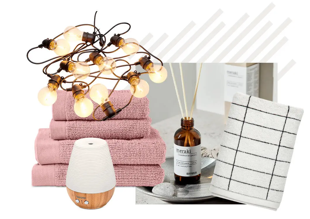 Her ses et udvalg af produkter til hjemmet med rosa håndklæder, en lyskæde, en Beurer aroma diffuser, en Meraki duftdiffuser og et hvidt håndklæde med sort ternet mønster. Produkterne er arrangeret samlet mod en lys baggrund.