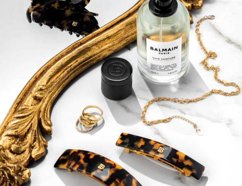 Her ses en hvid baggrund med en masse forskellige accessories, primært i guldige farver.