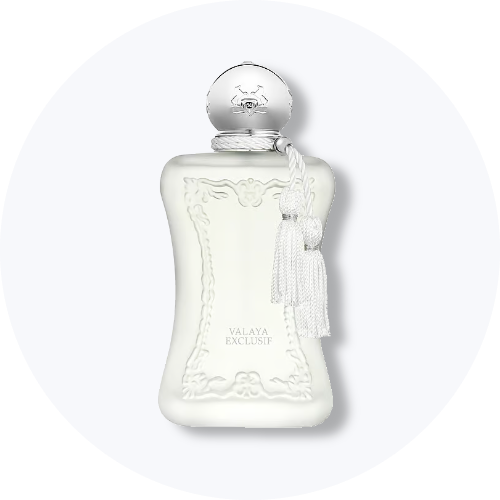 Her ses et billede af en parfumeflakon fra Parfums de Marly placeret centralt mod en lys, rund baggrund. På flakonen står teksten “VALAYA EXCLUSIF”. Flakonen er i hvid nuance med dekorative detaljer og en kvast ved halsen.