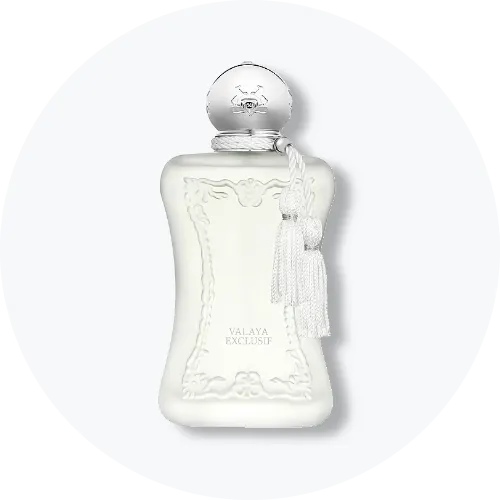 Her ses et billede af en parfumeflakon fra Parfums de Marly placeret centralt mod en lys, rund baggrund. På flakonen står teksten “VALAYA EXCLUSIF”. Flakonen er i hvid nuance med dekorative detaljer og en kvast ved halsen.