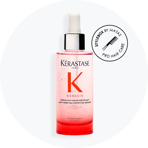 Her ses et hårserum fra Kérastase placeret mod en lys baggrund. På flasken står teksten “KÉRASTASE PARIS GENESIS Anti Hair-Fall Fortifying Serum”. Flasken er i klare og pink nuancer med pipette, og ved siden af ses et rundt mærke med teksten “STYLEBOX BY MATAS PRO HAIR CARE”.