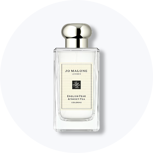 Her ses et billede af en parfumeflakon fra Jo Malone London placeret centralt mod en lys, rund baggrund. På flakonen står teksten “JO MALONE LONDON ENGLISH PEAR & SWEET PEA COLOGNE”. Flakonen er i klart glas med sølvfarvet låg.