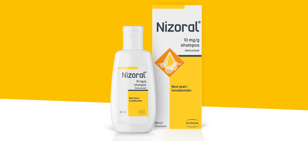 Her ses et billede af en flaske og en æske med produktet “Nizoral” placeret mod en gul og hvid baggrund. På emballagen står teksten “Nizoral 10 mg/g shampoo Ketoconazol” samt “Mod skæl i hovedbunden”.