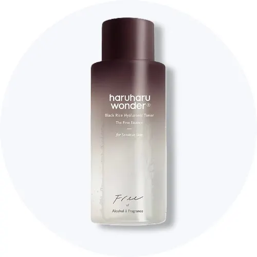 Her ses en Haruharu Wonder Black Rice Hyaluronic Toner Free i en brun og gennemsigtig flaske på en lys baggrund.