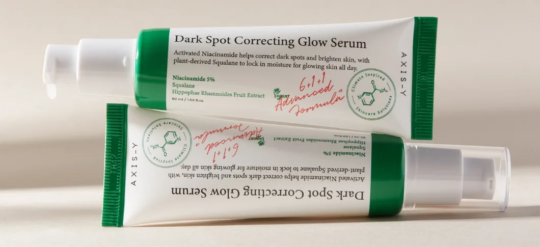 Her ses AXIS-Y serum i hvid og grøn emballage på en lys beige baggrund.