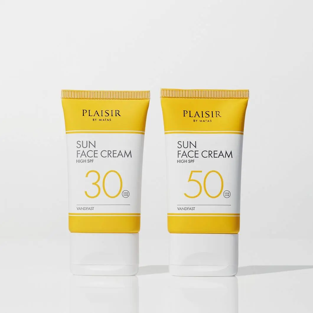 To ansigtssolcremer fra Plaisir by Matas står side om side på en lys baggrund. Produkterne er i gule og hvide tuber med solfaktor 30 og 50 tydeligt markeret på forsiden. Designet er enkelt og minimalistisk med fokus på solbeskyttelse til ansigtet.