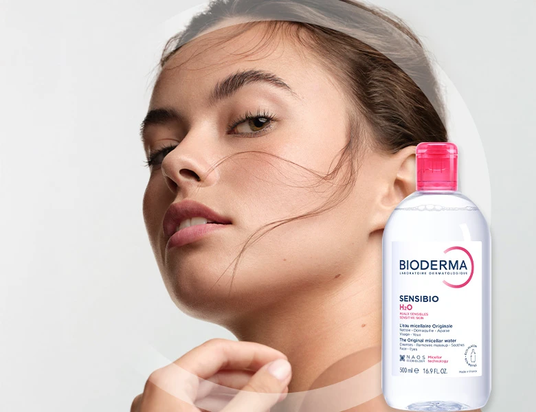 En kvindes ansigt med en flaske Bioderma Sensibio H2O The Original micellar water, 500 ml.