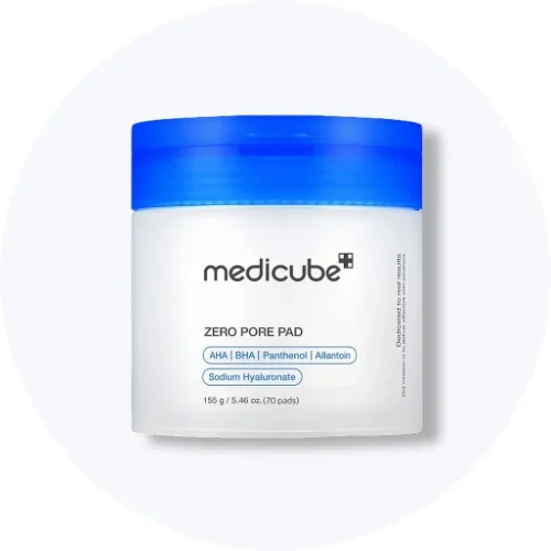 Her ses en Medicube Zero Pore Pad i en hvid krukke med blåt låg på en lys baggrund.