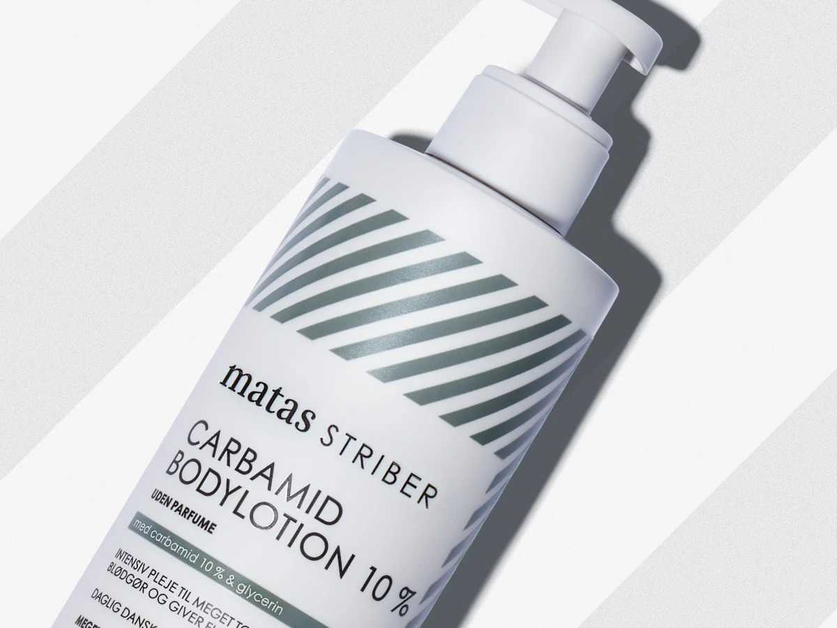 Hvid Matas Striber Carbamide Bodylotion 10% flaske med pumpe, mærket 'uden parfume' og 'med carbamid 10% & glycerin'.