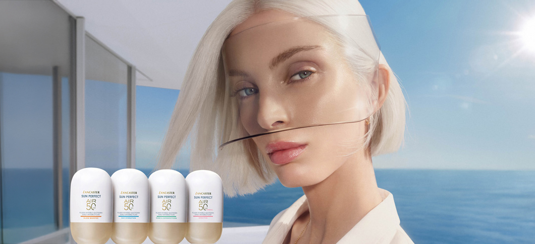 Her ses en kvinde foran havet i sollys sammen med Lancaster solprodukter i lyse flasker.