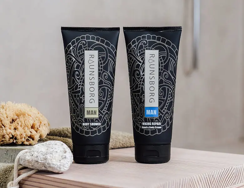 Her ses to sorte produkter, som har hvide mønstre på sig. De står på en lys træoverflade.