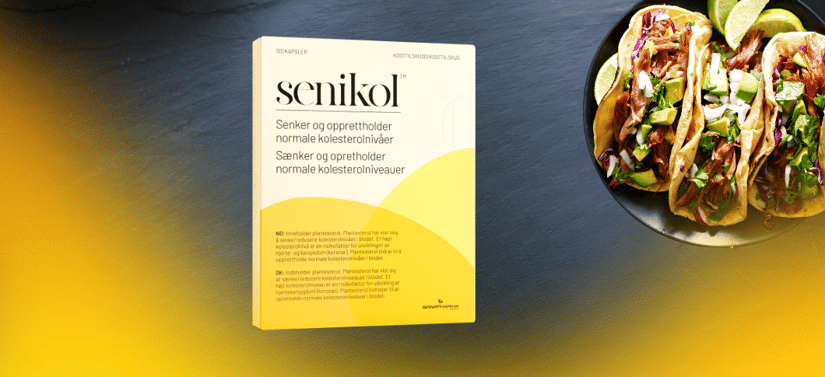 Pakke med Senikol kosttilskud står på mørk baggrund med gul farve nederst, ved siden af en tallerken med tacos og lime.