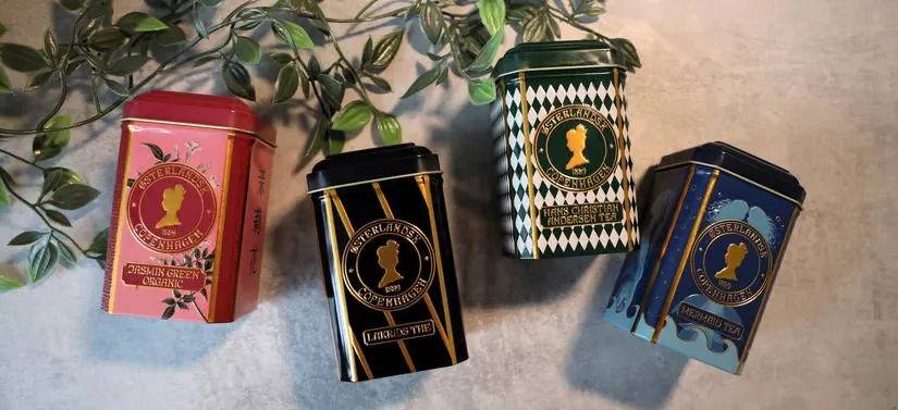 Her ses fire Østerlandsk produkter liggende på en grå baggrund med en grøn gren. 