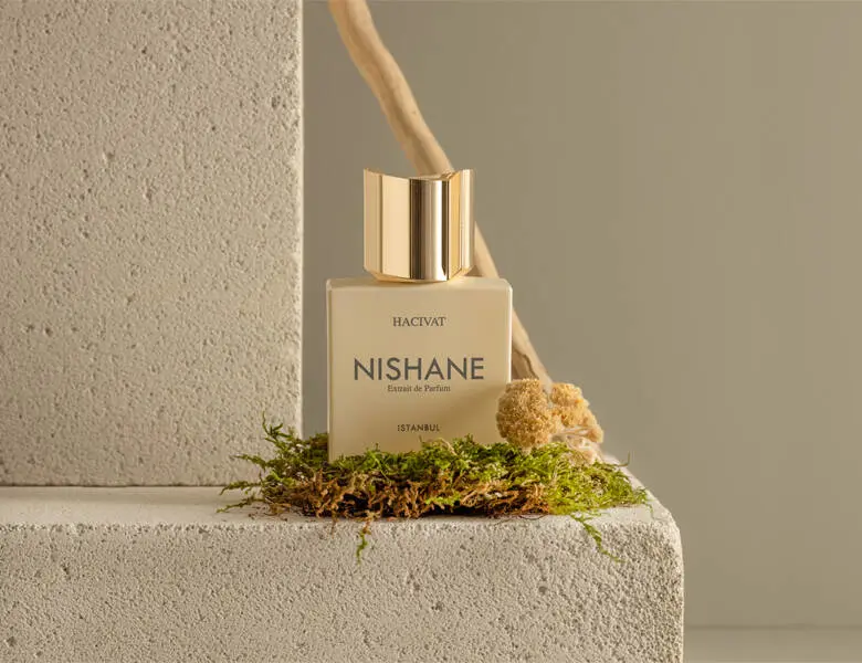 Her ses en Nishane parfume på noget mos og sandfarvede sten.