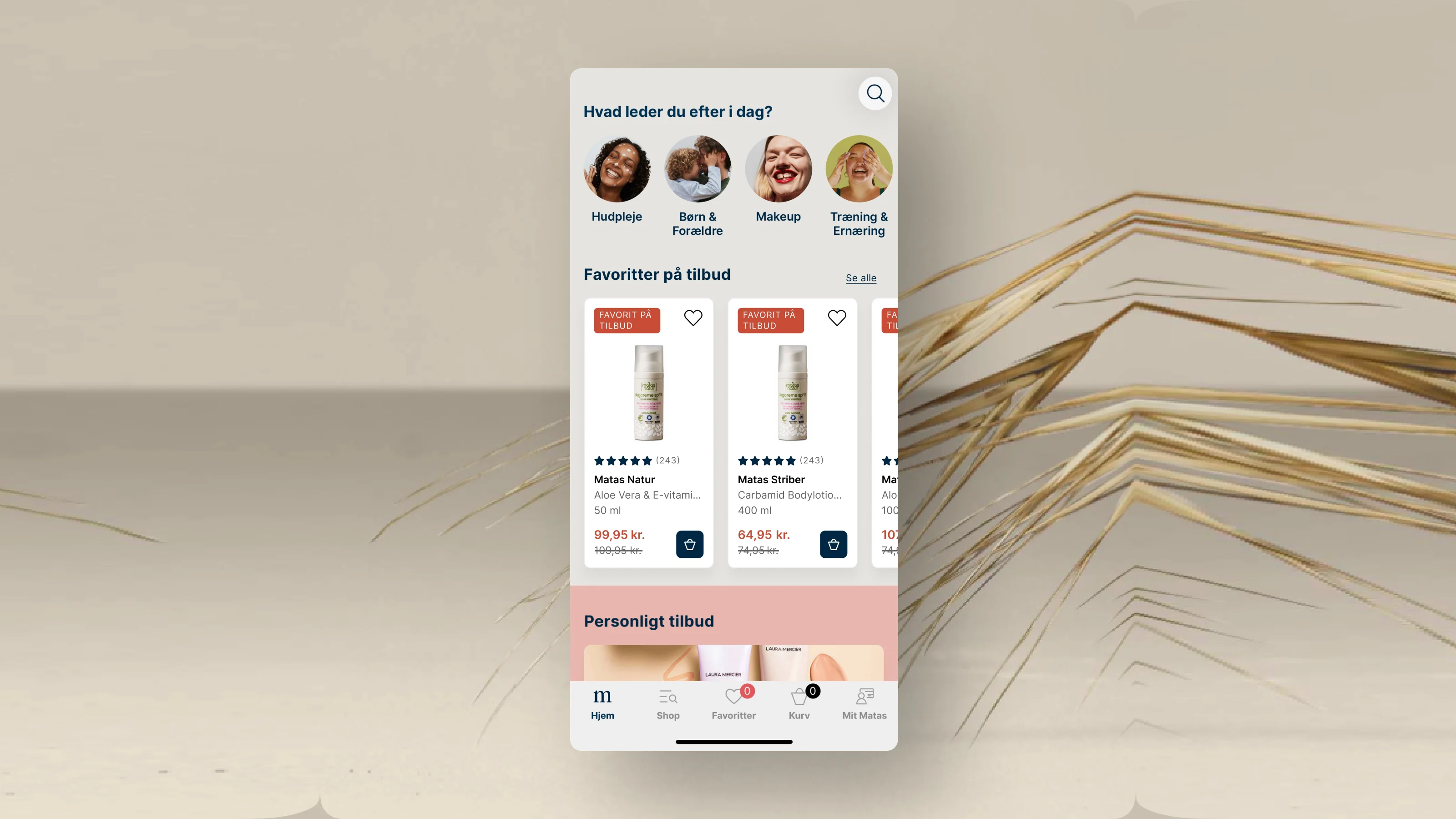 Her ses en mobil, hvor man på skærmen ser favoritter på tilbud på matas-appen. Baggrunden er beige med et halmstrå.