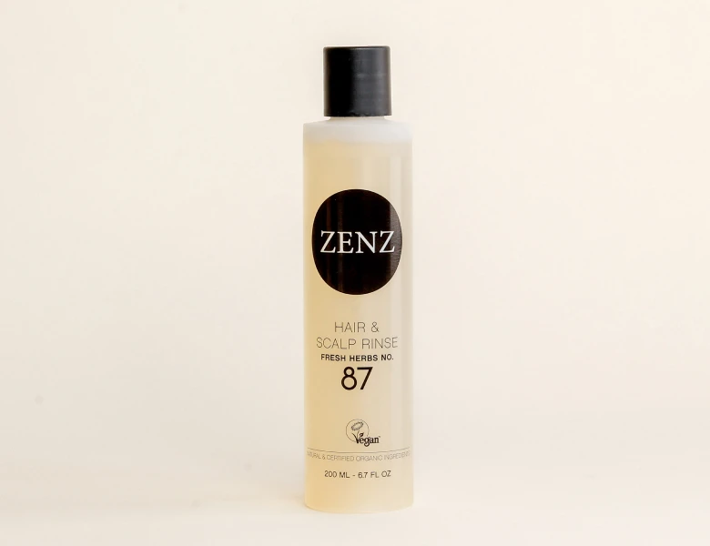 Her ses en ZENZ hair & scalp rinse i en lys flaske med sort låg på en lys baggrund.