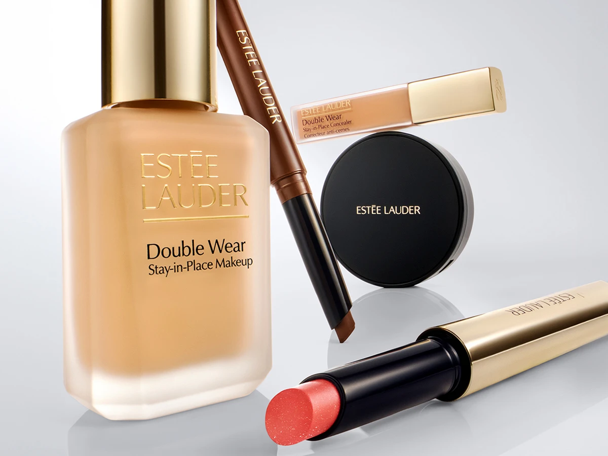 Estée Lauder Double Wear Stay-in-Place foundation, concealer, pudderkompakt, koralfarvet læbestift og øjenbrynspen.