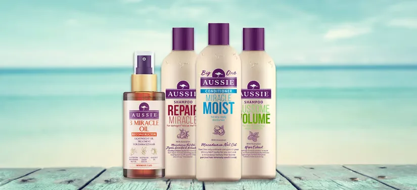 Her ses fire Aussie produkter på en badebro med havet som baggrund. 