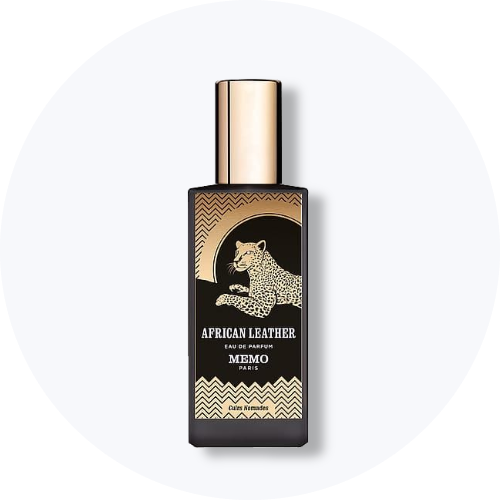 Her ses et billede af en parfumeflakon fra Memo Paris placeret centralt mod en lys, rund baggrund. På flakonen står teksten “AFRICAN LEATHER EAU DE PARFUM MEMO PARIS”. Flakonen er sort med guldfarvede detaljer og illustration af et dyr på fronten.