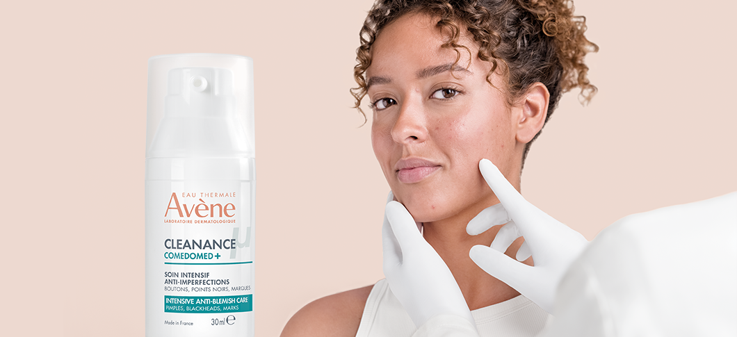 Her ses en kvinde sammen med Avène hudplejeprodukt, mens en hånd peger på huden i ansigtet på en lys beige baggrund.