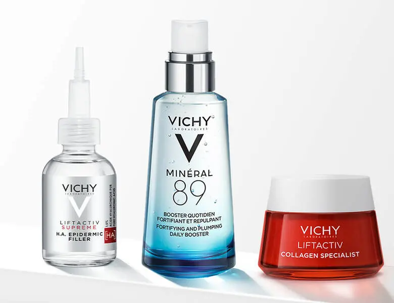 Her ses tre Vichy produkter på række - et sølv, et blåt og et rødt produkt. Baggrunden er hvid.