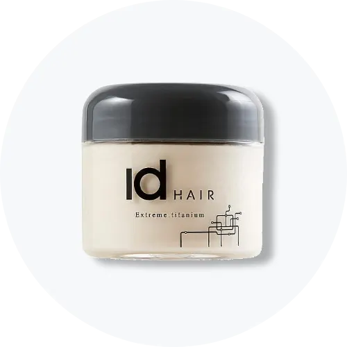 Her ses et billede af et hårprodukt fra Id Hair placeret centralt mod en lys, rund baggrund. På krukken står teksten “Id HAIR Extreme titanium”. Krukken er i lyse nuancer med mørkegråt låg.