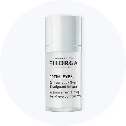 Her ses Filorga Optim-Eyes i en hvid flaske på en lysegrå cirkel.