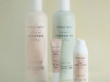 Fire produkter fra Matas Natur står samlet foran en lys og neutral baggrund. Produkterne består af shampoo, shower gel, håndcreme og en lille tube med hudpleje i lyse pastelnuancer som rosa, mintgrøn og beige. Emballagerne er enkle med hvid tekst og små certificeringsikoner nederst. Produkterne står tæt sammen i blødt lys, hvilket giver billedet et roligt og naturligt udtryk.