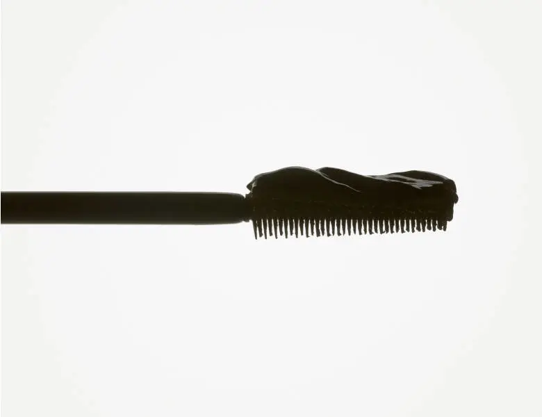 Her ses en hvid baggrund med en sort mascara stav.