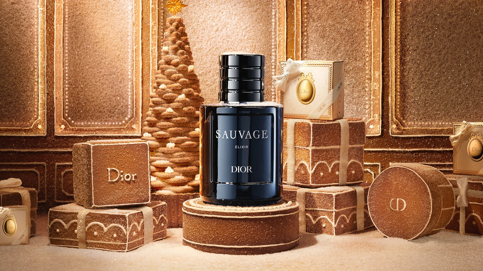 Dior Sauvage Elixir parfume i en festlig, sukkerdækket honningkage-juledekoration med gaveæsker og juletræ.