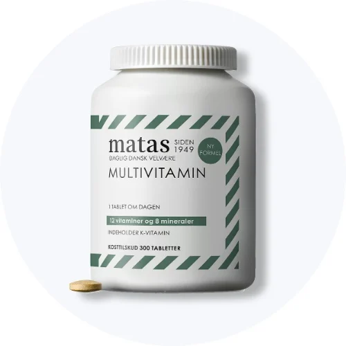 Matas multivitamin i hvid bøtte med grønne striber og en tablet foran på lys grå baggrund.