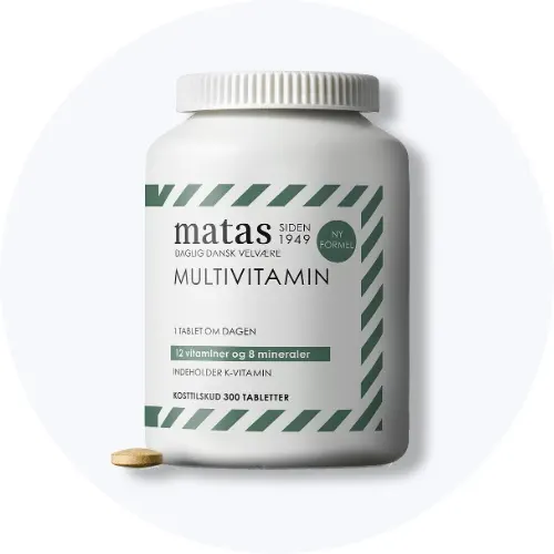 Matas multivitamin i hvid bøtte med grønne striber og en tablet foran på lys grå baggrund.