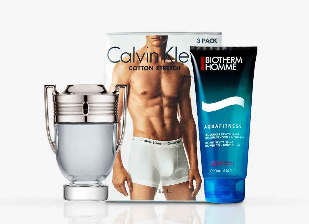 Her ses et udvalg af produkter til mænd med Rabanne Invictus, en Calvin Klein Cotton Stretch 3-pack med underbukser og Biotherm Homme Aquafitness Shower Gel. Produkterne står samlet mod en lys baggrund.
