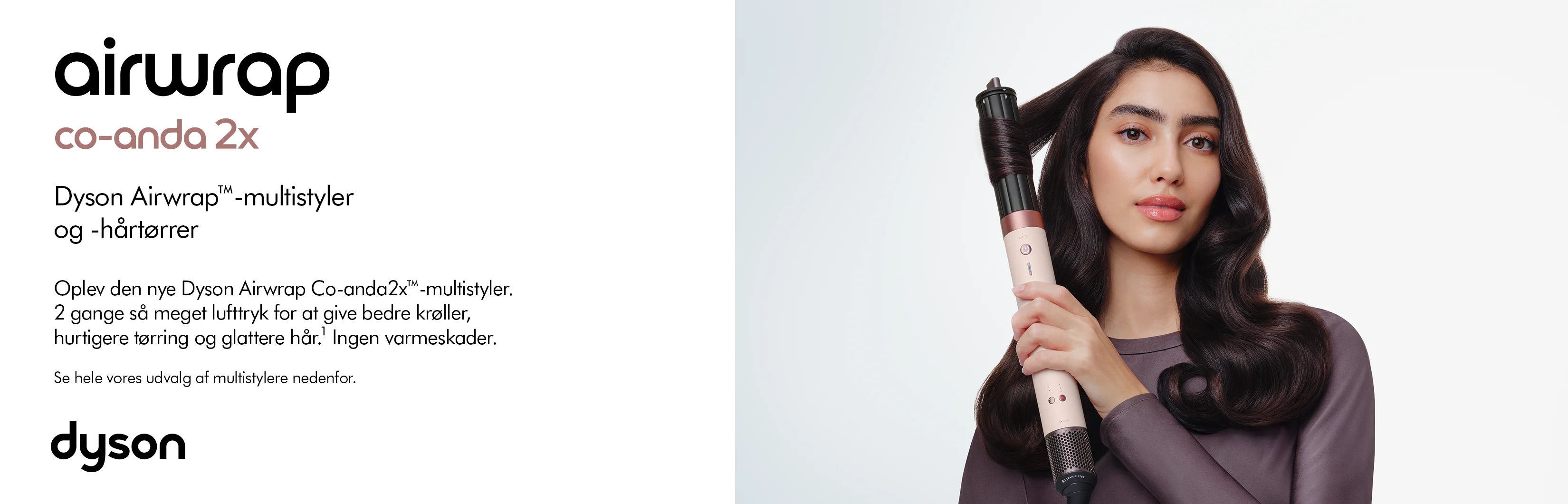 Her ses et kampagnebillede for Dyson Airwrap Co-anda2x multistyler og hårtørrer. Til højre ses en person med langt, bølget hår, som holder Airwrap-styleren med håret viklet omkring stylingtilbehøret. Til venstre fremhæves produktets 2 gange så kraftige lufttryk, der skal give bedre krøller, hurtigere tørring og glattere hår uden varmeskader. Det minimalistiske layout suppleres af Airwrap Co-anda2x- og Dyson-logoerne.