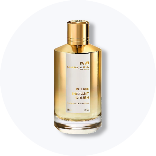Her ses et billede af en parfumeflakon fra Mancera placeret centralt mod en lys, rund baggrund. På flakonen står teksten “MANCERA PARIS INTENSE INSTANT CRUSH”. Flakonen er i guldfarvet design med klart glas i bunden.