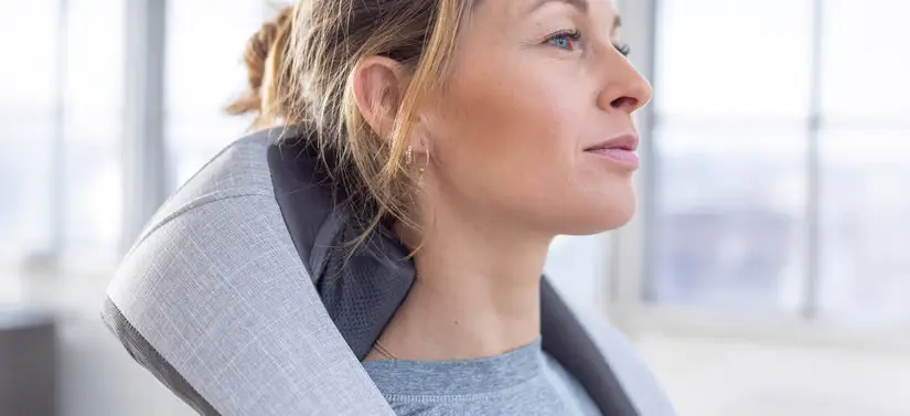 Her ses en kvinde, som benytter et Sharper Image produkt på nakken.