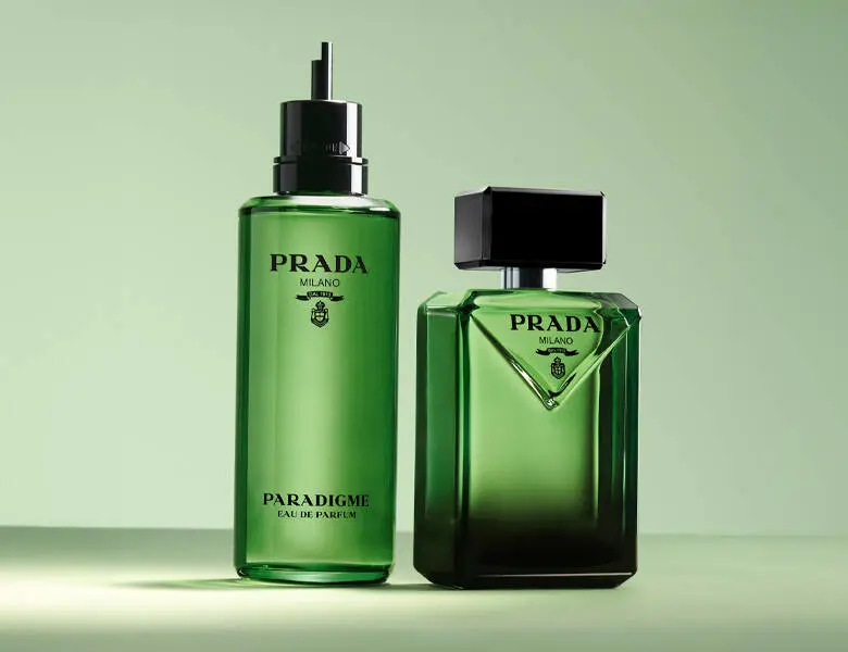 Her ses en lysergrøn baggrund med en grøn Prada parfume og dens refill version. 