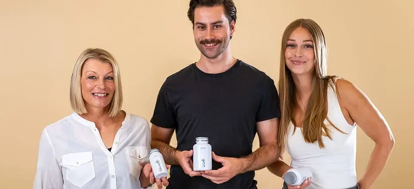 Her ses en lysegul/brunlig baggrund med tre personer. En høj mand i midten i sort t-shirt. Ved hver hans side står en kvinde. Til venstre en middelaldrende kvinde i hvis skjorte og til højre en ung kvinde i hvid ærmeløs trøje. De holder alle et PureViva produkt og kigger smilende ind i kameraet.