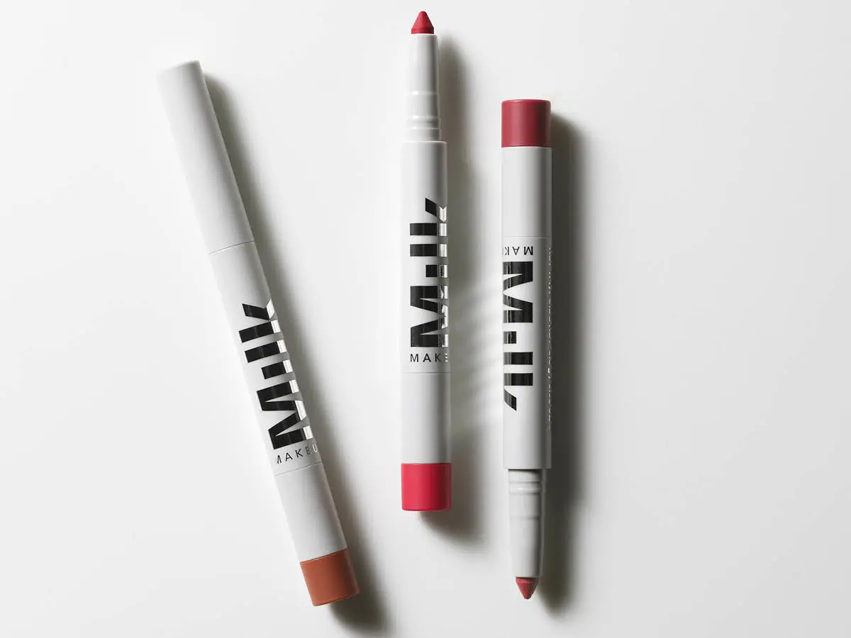 Her ses tre læbeprodukter fra Milk Makeup i hvid emballage. Produkterne ligger på en hvid baggrund og viser forskellige nuancer i rosa, rød og brun.