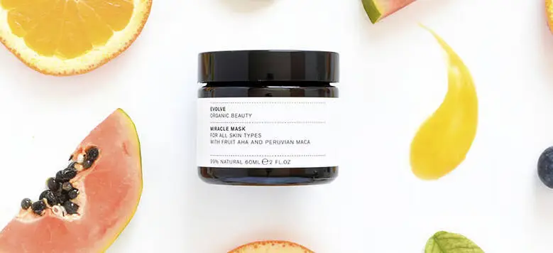 Her ses en hvid baggrund med et produkt i midten. Rundt om ses en masse frugt.