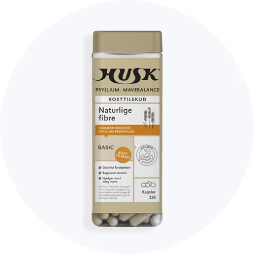 HUSK Psyllium Mavebalance kosttilskud med naturlige fibre i gennemsigtig beholder med beige låg og kapsler i bunden på lys grå baggrund.