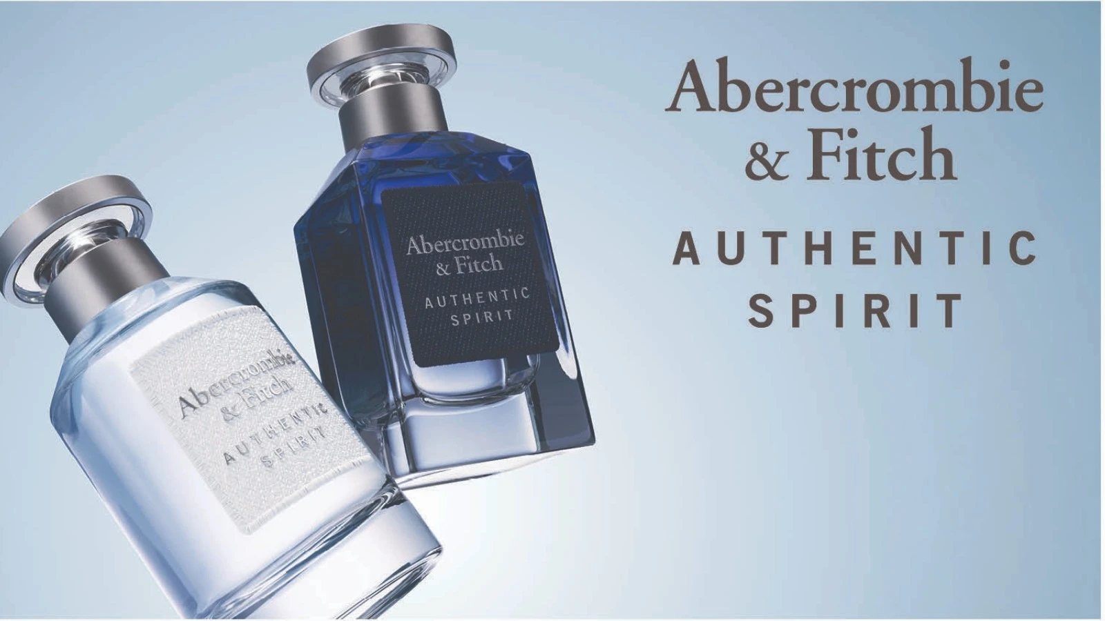 Her ses to Abercrombie & Fitch Authentic Spirit-parfumeflakoner i lyseblå og mørkeblå nuancer med sølvfarvede låg mod en lyseblå baggrund.