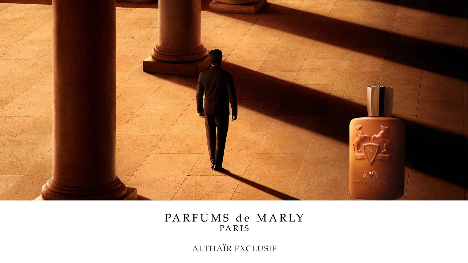 Parfums de Marly Althaïr Exclusif: Mand går på flisegulv mellem søjler, ved siden af brun parfumeflaske.