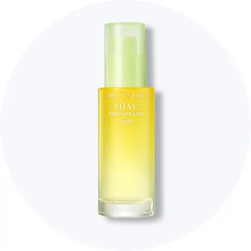 Her ses et Goodal Green Tangerine Vita-C Dark Spot Care Serum i en gul pumpeflaske med lysegrønt låg på en lys baggrund.