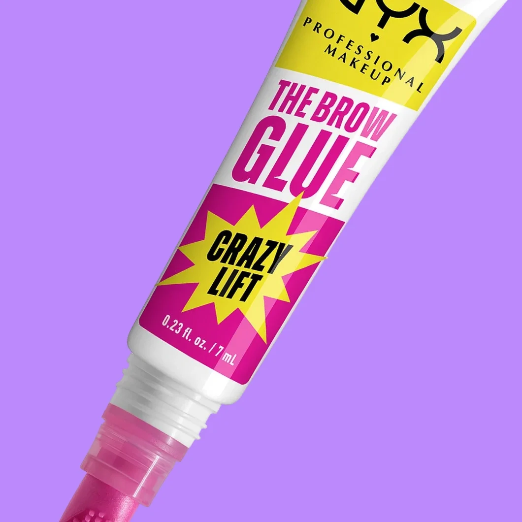 NYX Professional Makeup The Brow Glue Crazy Lift øyenbrynsprodukt i hvit, rosa og gul tube mot lilla bakgrunn. På emballasjen står «NYX PROFESSIONAL MAKEUP», «THE BROW GLUE», «CRAZY LIFT» og «0.23 fl. oz. / 7 mL».