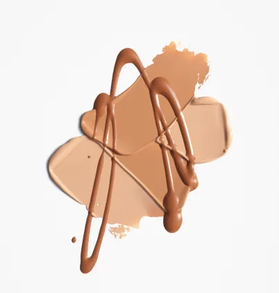 Olika nyanser av beige och brun foundation utsmetade på en vit bakgrund.