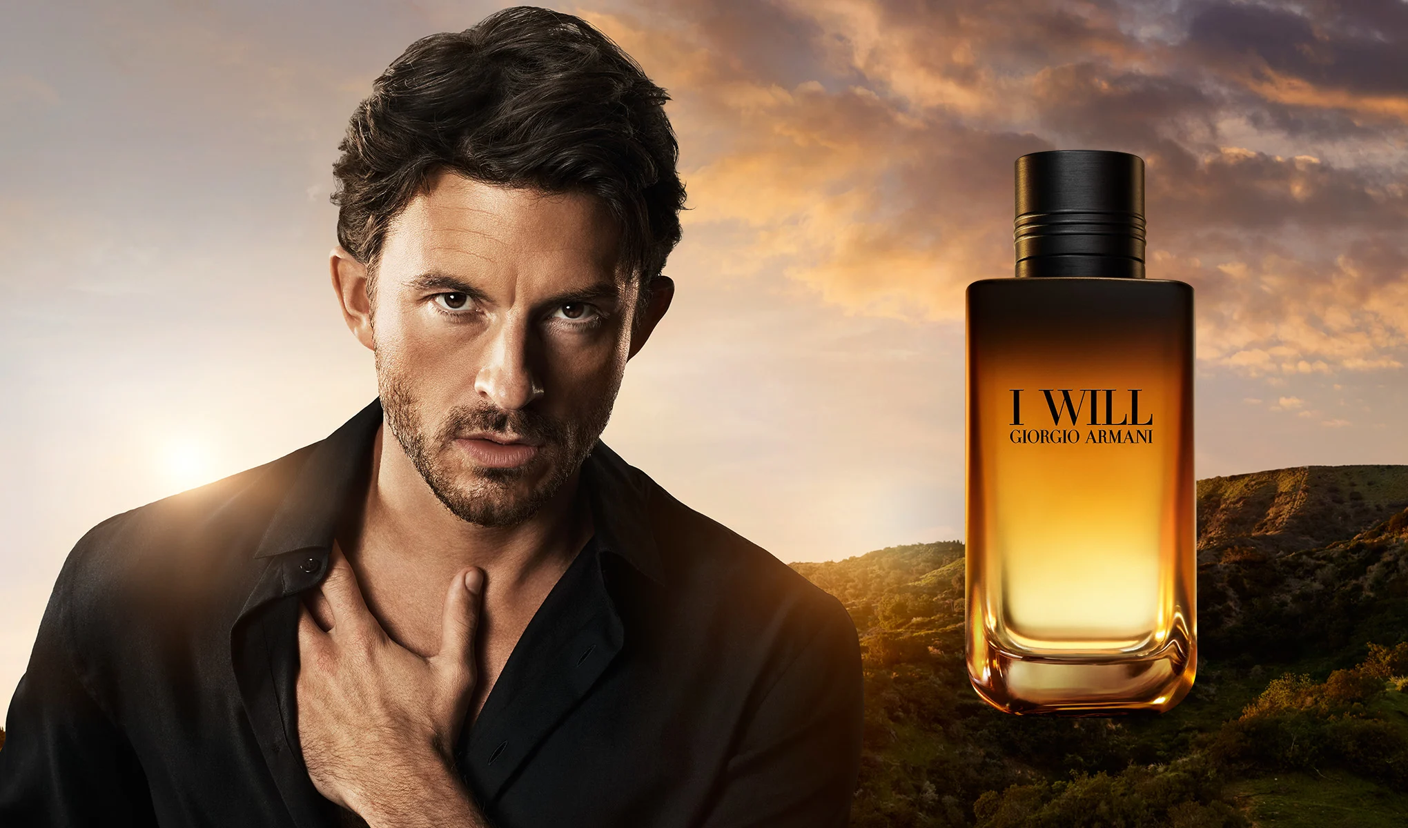 Mies ja Giorgio Armani I Will -tuoksupullo auringonlaskussa.