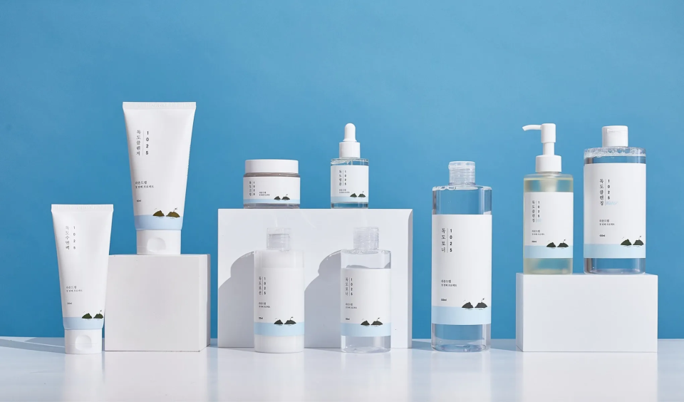 Flere hvite hudpleieprodukter mot en blå bakgrunn. Produktene inkluderer kremer, serum og rensemidler.