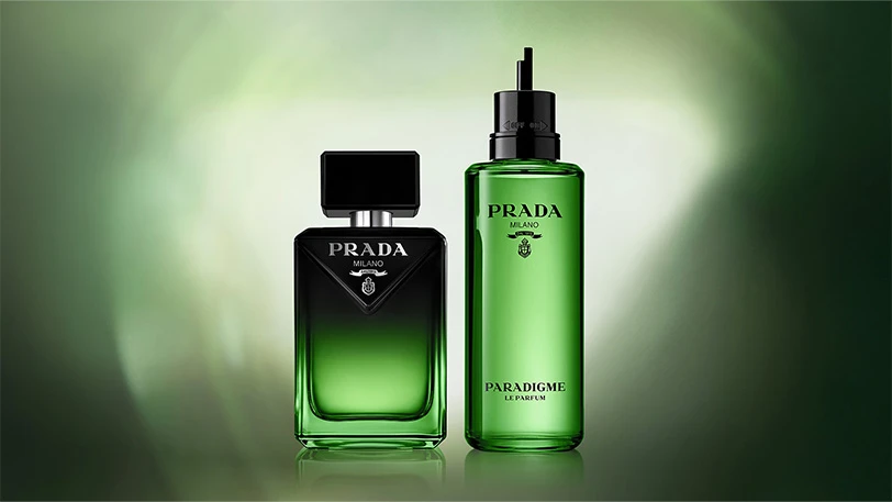 To Prada parfymeflasker: en rektangulær grønn-svart flaske og en sylindrisk grønn Paradigme Le Parfum flaske.